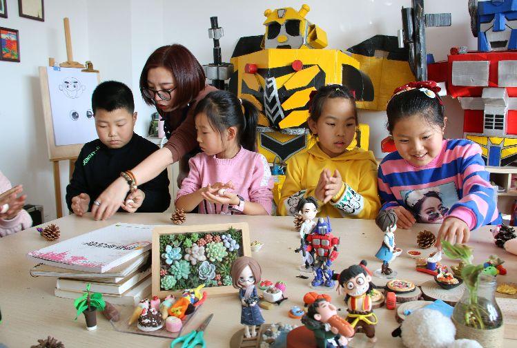 志愿者在介子路社區(qū)教孩子們做手工。  本報記者  盤小美  攝  