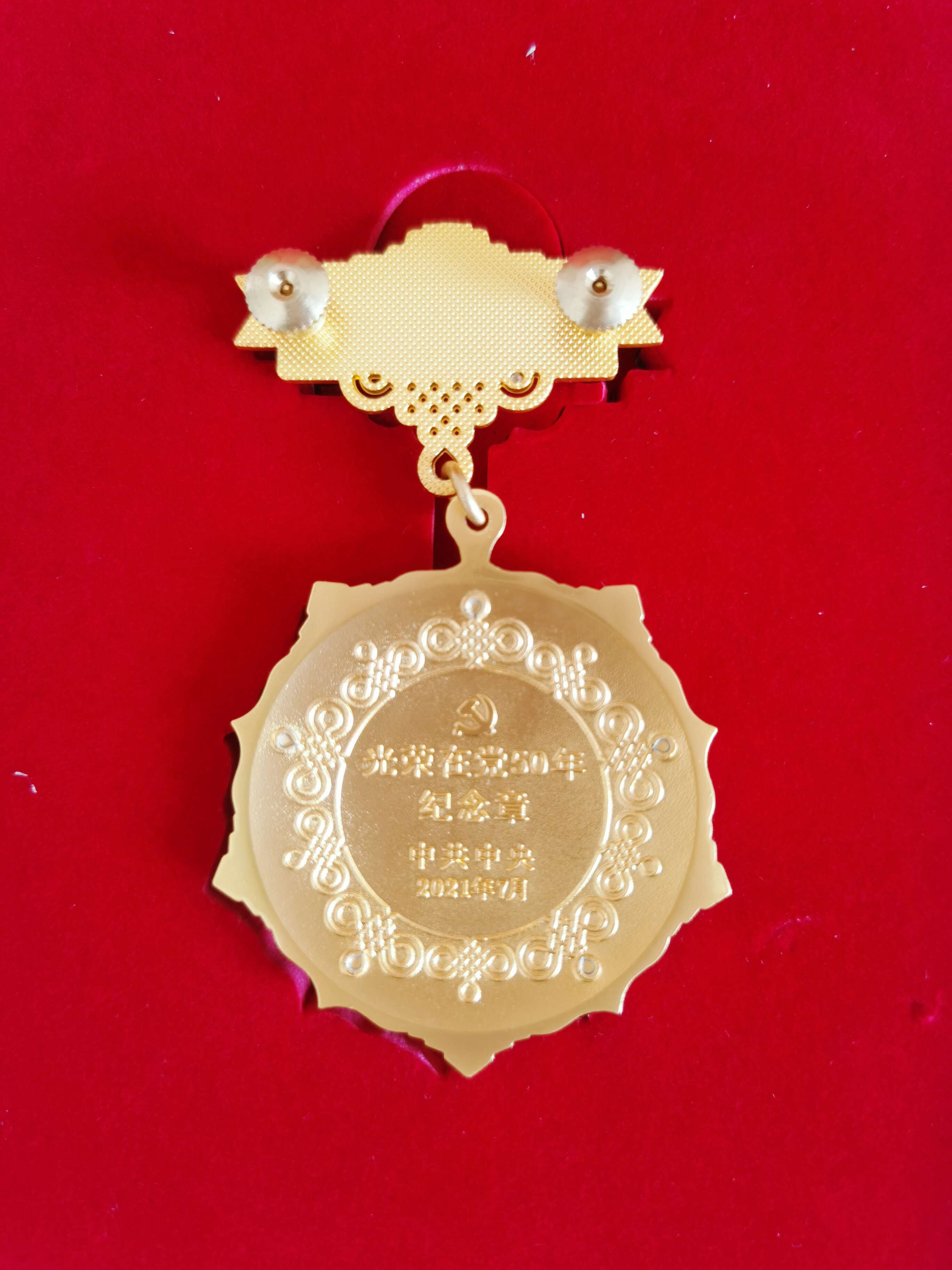 光榮在黨50年紀念獎章背面。  閆慧/攝