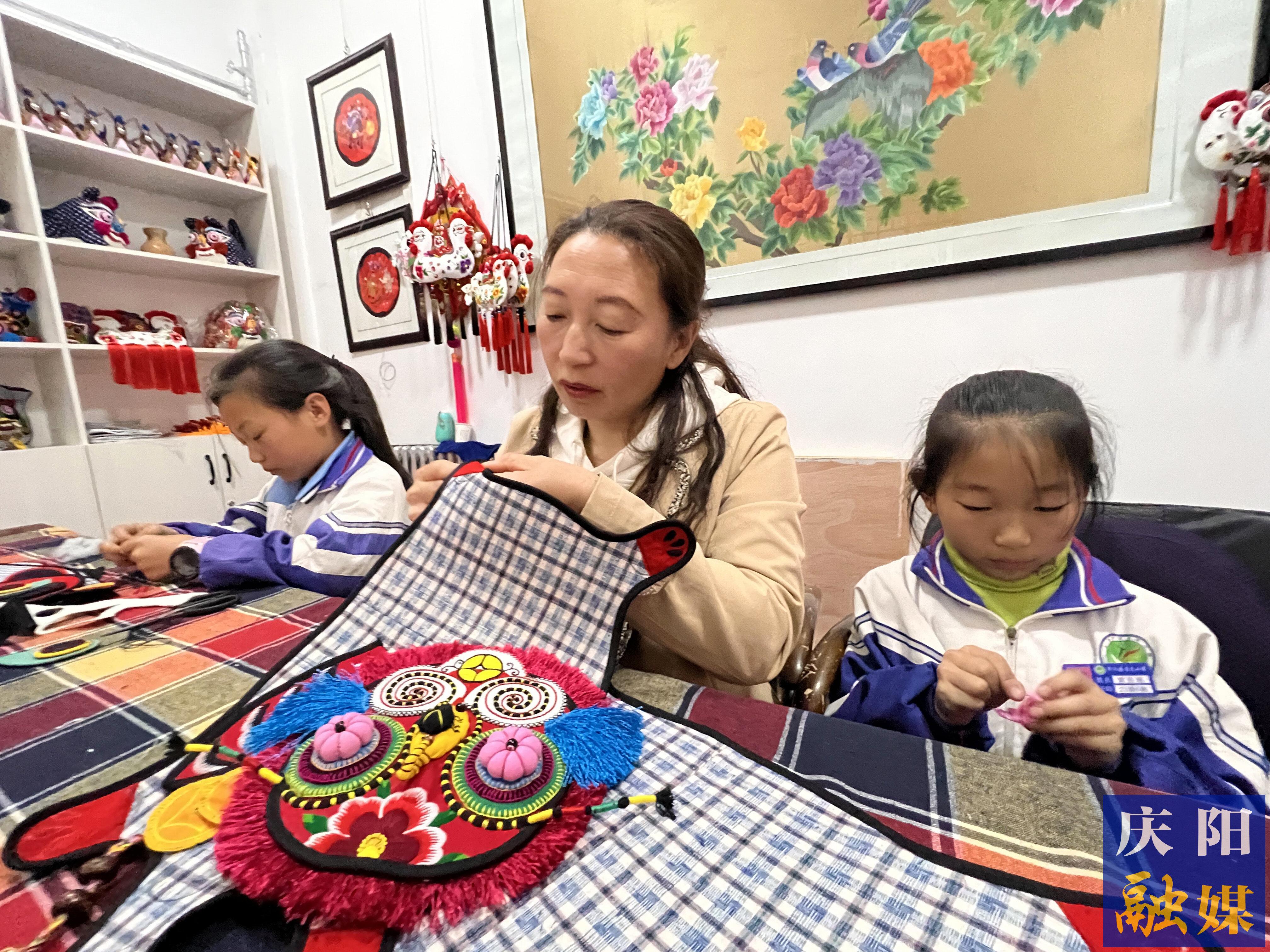李富梅帶著自己的孩子完成刺繡作品。