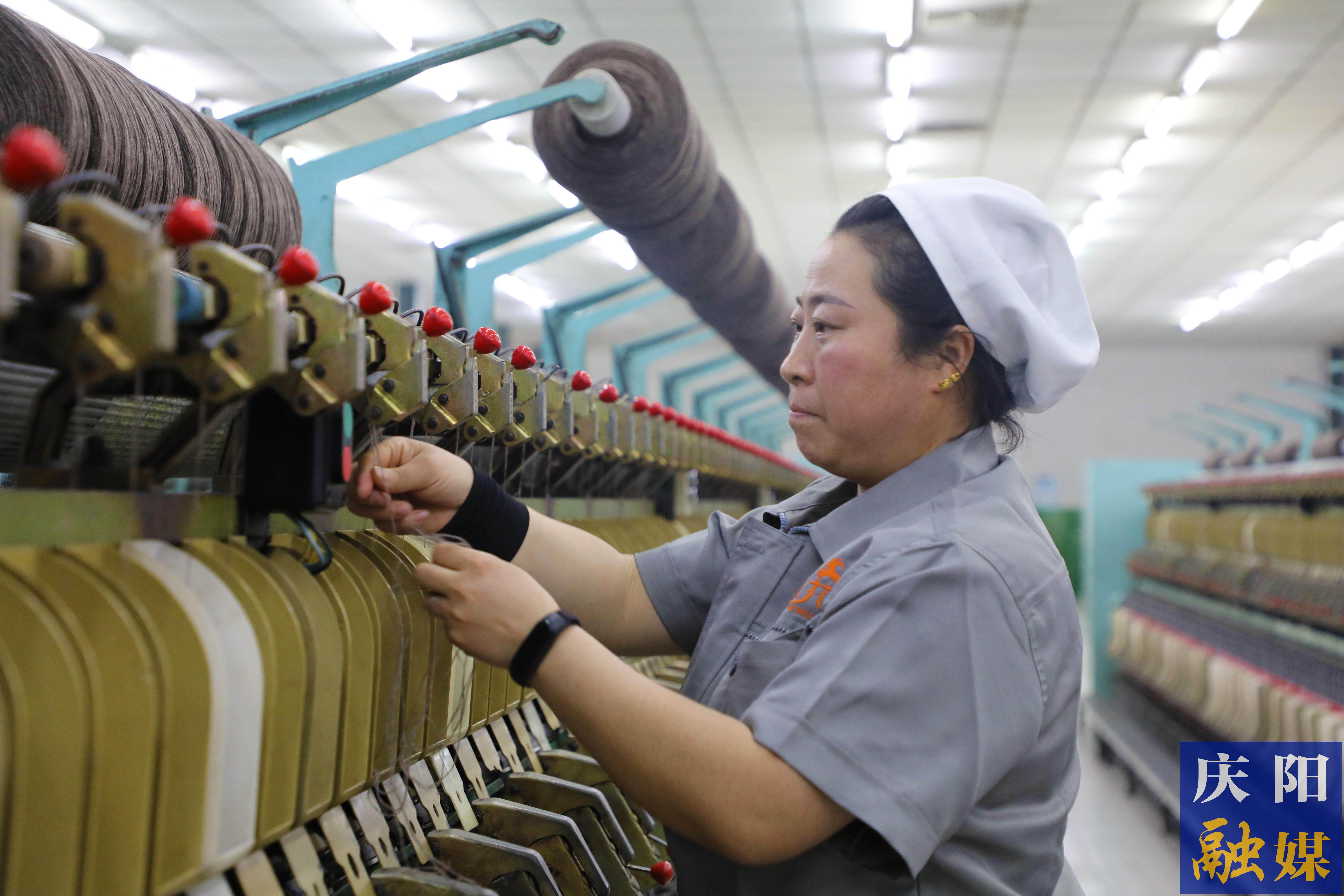 在鎮(zhèn)原縣解語(yǔ)花山羊絨制品有限責(zé)任公司紡紗車間，擋車工龐小麗熟練地操作著機(jī)器。 慶陽(yáng)融媒記者 閆慧 攝